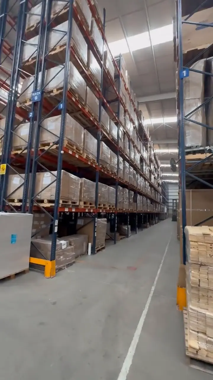 Pasillo de racks con tarimas listas para despacho
