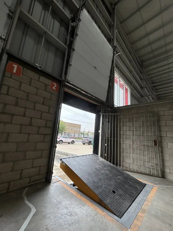 Andén numerado de la bodega de Mubit con su rampa niveladora, visto desde adentro