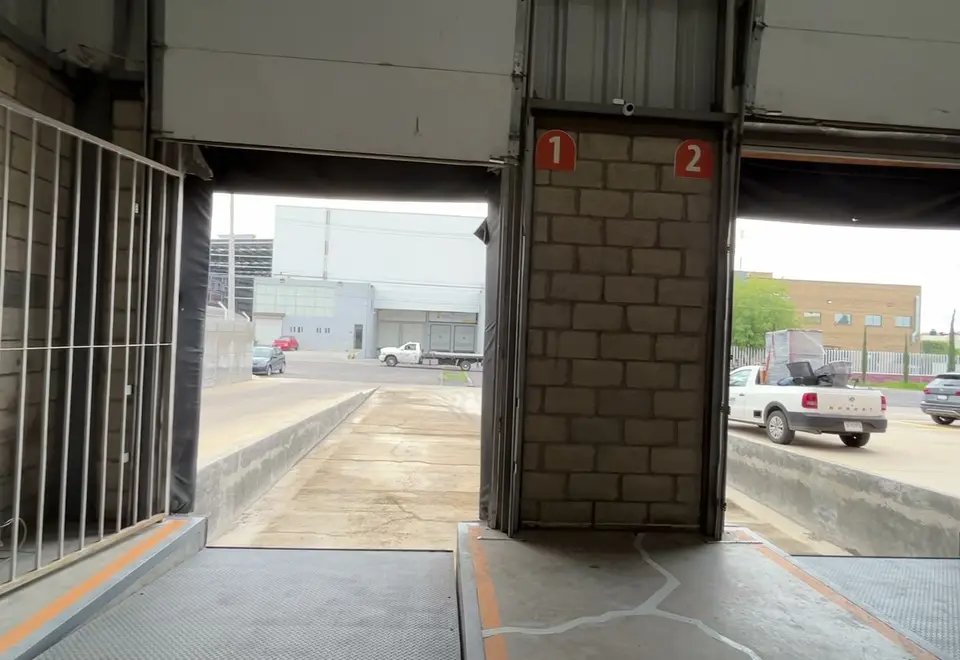 Andenes 1 y 2 de la bodega de Mubit Logística vistos desde adentro, con las rampas niveladoras y la calle al fondo