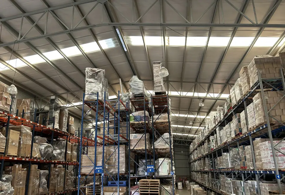 Racks de varios niveles con tarimas y letreros de rack dentro del almacén de Mubit Logística